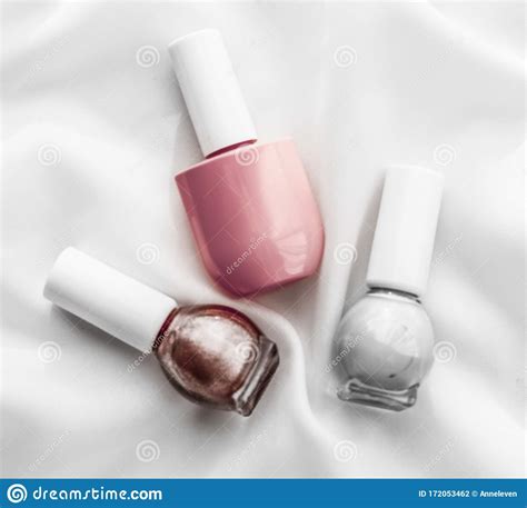 Nail Polish Bottles On Silk Background French Manicure Products And