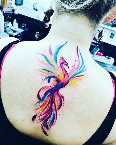 A Woman With A Colorful Bird Tattoo On Her Back