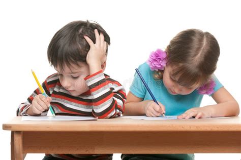 Two Children Sit At The Desk And Write Stock Photo Image Of