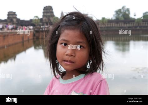 Young Poor Girl Aged 4 In Front Of River At Famous Angkor Wat In Siem
