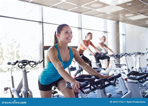 Group Of Women Riding On Exercise Bike In Gym Stock Photo Image Of
