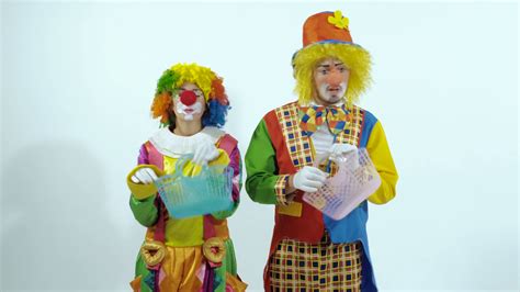 Portrait Of Two Clowns Having Fun Together Holding Little Baskets Stock