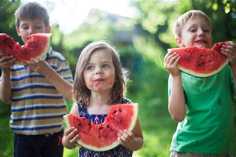 Premium Photo Cheerful Happy Children Eat Watermelon In The Garden