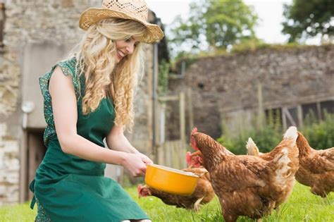 Premium Photo Young Woman Feeding Her Chickens