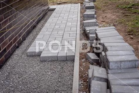 Photograph Laying Gray Concrete Paving Slabs In A House Walkway