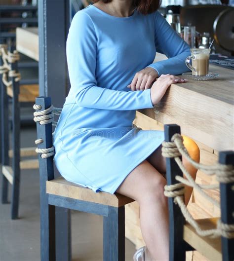 Girl In Blue Dress Sits At A Bar Counter And Drinks Coffee Turns Around