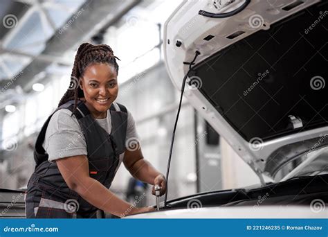Black Female Mechanic Holding Wrench Checking Up On The Car Engine For