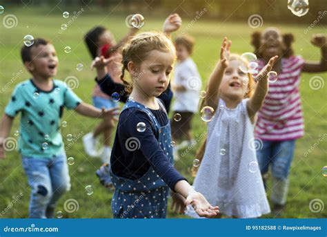 Group Of Kindergarten Kids Friends Playing Blowing Bubbles Fun Stock