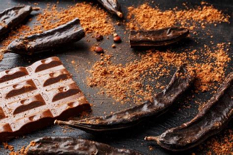 Carob Fruit On A Black Background With Chocolate Out Delicious And