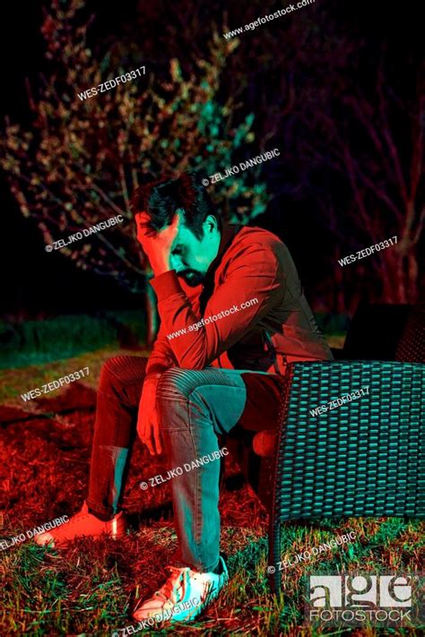 Sad Man Sitting Alone On Garden Bench At Night Stock Photo Picture