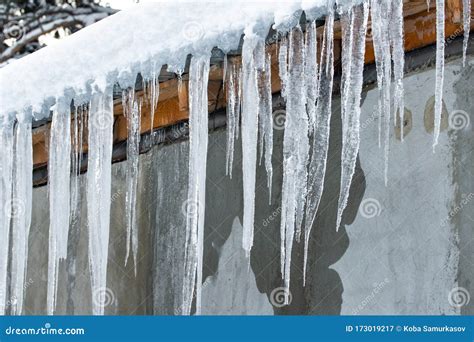 Icicles Hang From The Snowy Roof Of A Mountain Cottage Stock Image