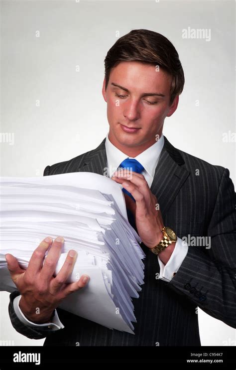Business Man Holding In His Arms A Lager Pile Of Paper Work Stock Photo