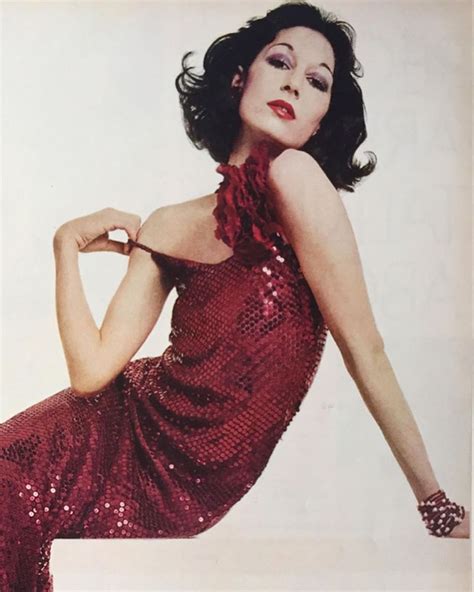 A Woman In A Red Sequined Dress Poses For A Photo With Her Hands On Her