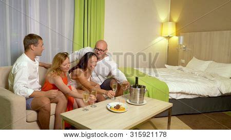 The Concept Of Bisexuals Bisexual Couples Exchange Partners At A Party At Home Image Stock