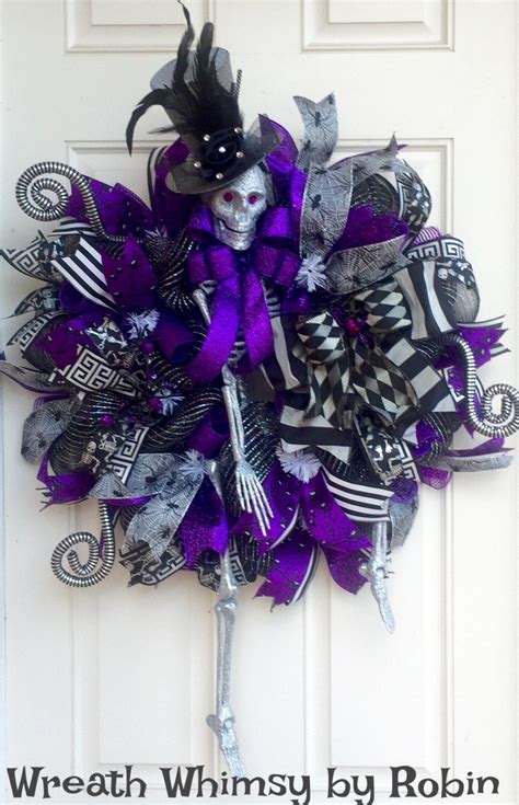 A Purple And Black Halloween Wreath Hanging On The Front Door