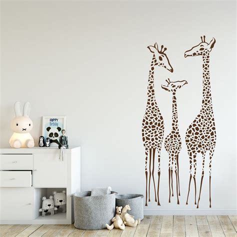 Two Giraffes Standing Next To Each Other On A Wall In A Room