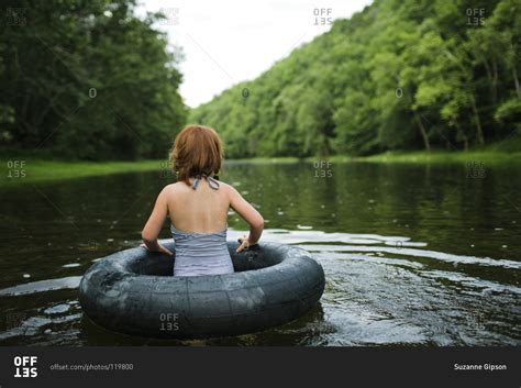 Little Girl Wading Into A River With An Inner Tube Stock Photo Offset