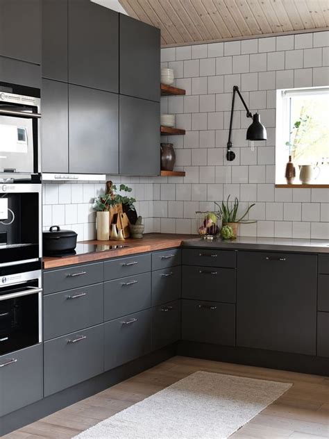 Cabinets are a key element of any kitchen. a contemporary graphite grey kitchen with white tiles and rich colored wooden countertops to ...