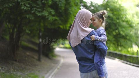 Muslim Mom And Her Little Daughter In Hijabs Are Hugging Sitting On The