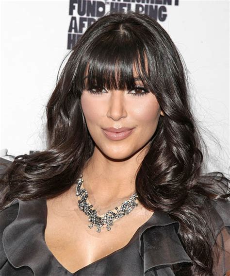 The long black shiny hair with sculpted waves creates her an old hollywood look. Kim Kardashian Long Wavy Casual Hairstyle with Blunt Cut Bangs