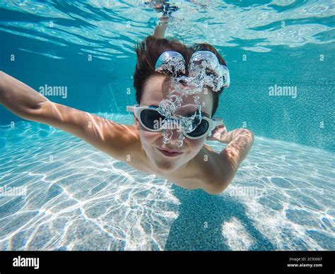 Underwater Image Of Boy Swimming In A Pool With Goggles On Stock Photo