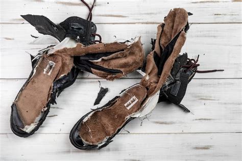 Premium Photo Torn Worn Shoes Boots Light Wooden Background Torn