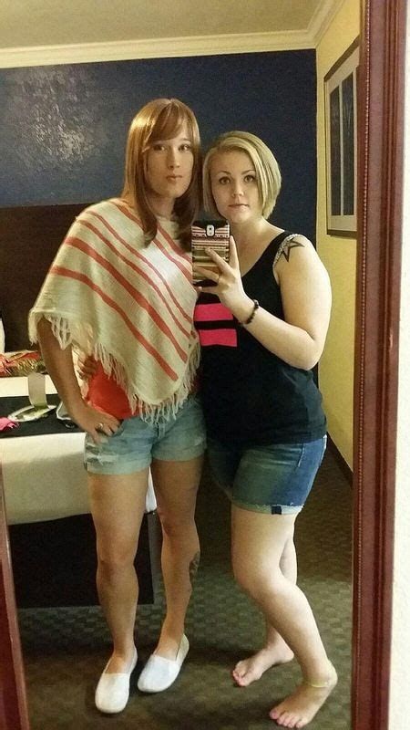 Two Women Standing In Front Of A Mirror Taking A Selfie
