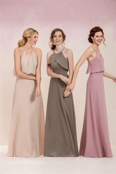 Three Women In Long Dresses Standing Next To Each Other