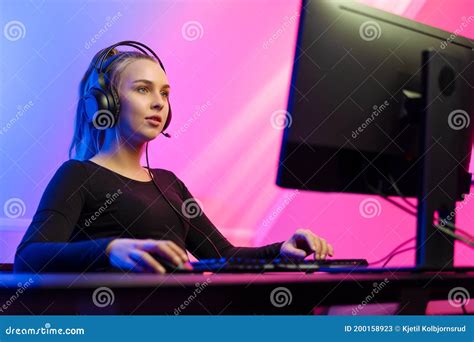 Focused Gamer Girl With Headset Playing Online Video Game On Pc Stock