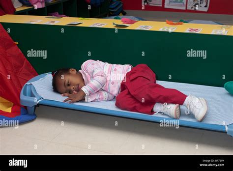 4 Year Old Preschool Girl Lying On A Cot During Nap Time At School