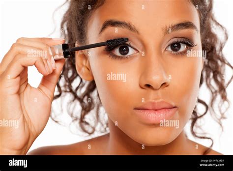 A Young Dark Skinned Woman Applying A Mascara To Her Eyelashes Stock