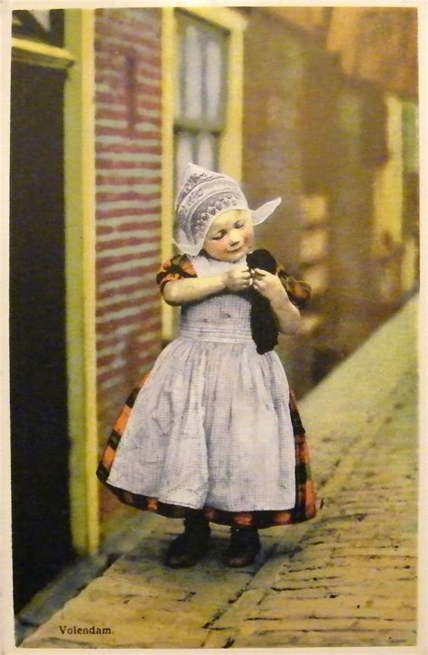 een volendammer meisje in dracht met jong poesje poserend op straat 1920 1931 vintage