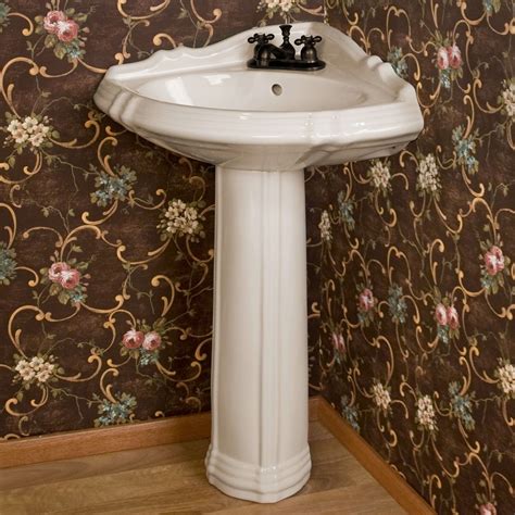 A White Pedestal Sink Sitting In Front Of A Wallpapered Wall Next To A