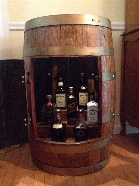 Wood whiskey (also spelled whisky) barrels. Whiskey barrel cabinet filled with Jack and Johnny ...