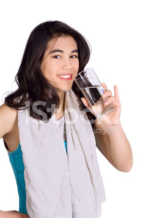 Beautiful Biracial Teenage Girl Drinking Water While Exercising Stock
