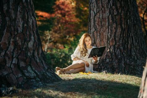 Beautiful Asian Woman In White Dress Sit Under The Tree Writing And Thinking In The Park With