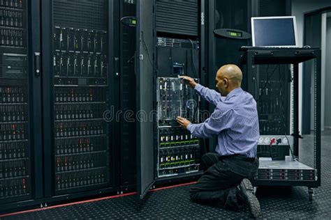 Database Software And A Man Engineer In A Server Room For