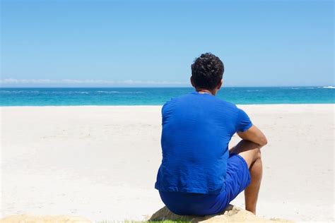 Un Hombre Sentado Solo En La Playa Foto Premium
