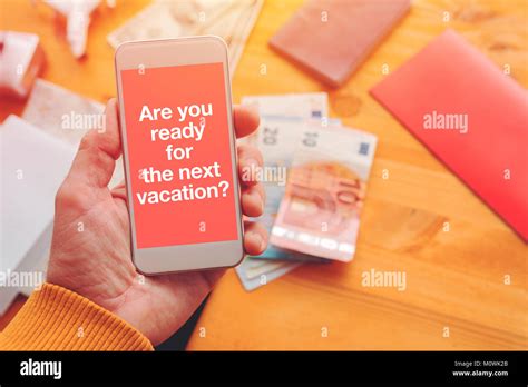 Are you ready for your next vacation. Man holding smartphone with mock