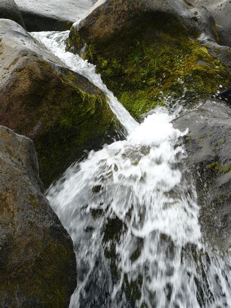 The Water Is Rushing Over The Rocks In The Stream
