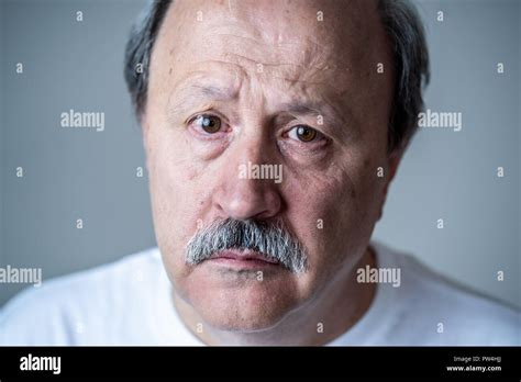 Portrait Of Older Adult Senior Man In Pain With Sad And Exhausted Face