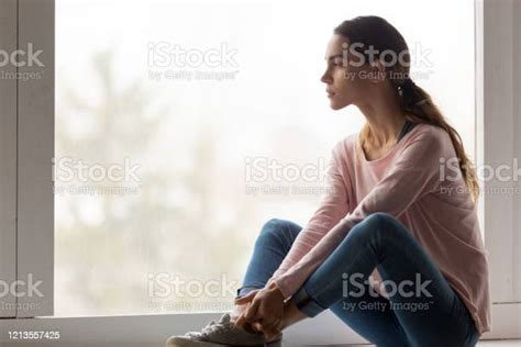 Sad Pensive Thoughtful Girl Sit On Sill Looking Through Window Stock