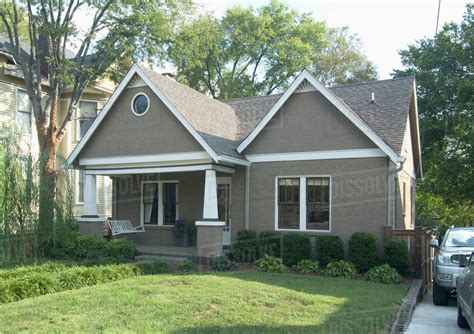 Front Exterior Of A One Story Bungalow With White Trim At Nashville