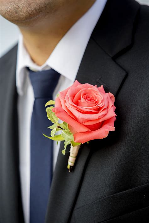 Peonies, lillies, roses, oh my! A bright coral colored rose for the groom's boutonniere ...