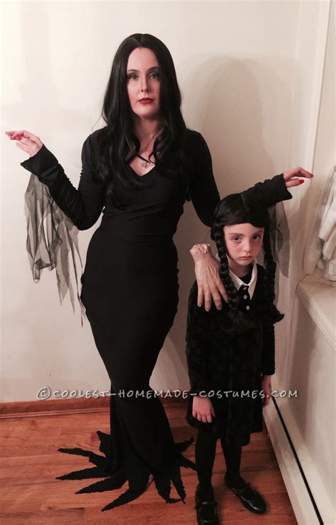 I love the sheer sleeves and length. Cool Homemade Mom and Daughter Couple Costume: Morticia and Wednesday Addams with Thing
