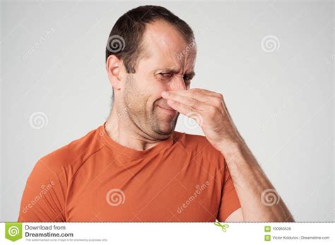 Caucasian Man Is Pinching Nose With Fingers And Looking With Disgust