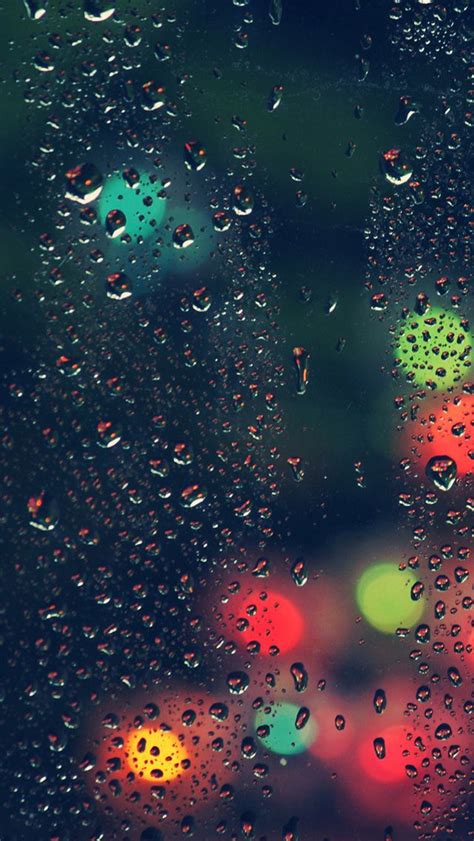 Raindrops On A Window With Traffic Lights In The Background