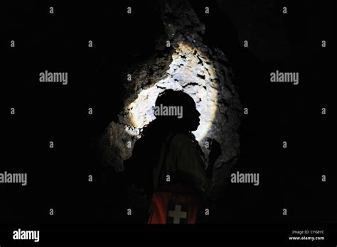 Silhouette Of A Woman Standing Inside A Cave Made With A Flashlight
