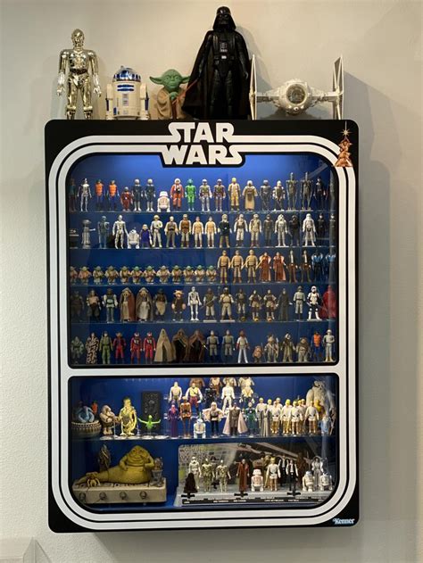 Star Wars Action Figures Are Displayed In A Display Case On The Wall