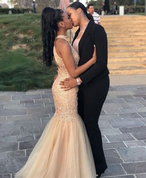 Two Women In Formal Wear Kissing Each Other On The Cheek While Standing Next To Some Steps
